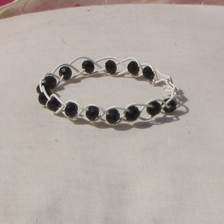 Ivory coloured copper plaited bracelet with black beads