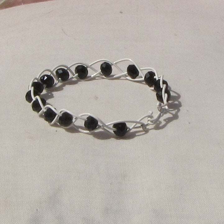 Ivory coloured copper plaited bracelet with black beads - detail